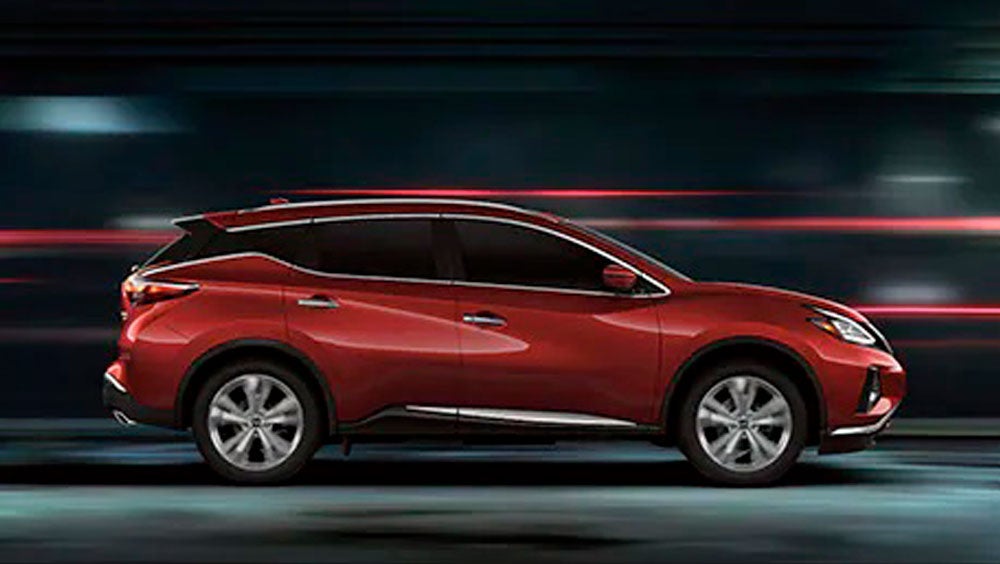 2023 Nissan Murano shown in profile driving down a street at night illustrating performance. | Don Moore Nissan in Owensboro KY